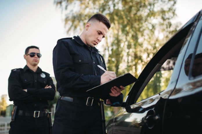 Police officers writing an arrest report.